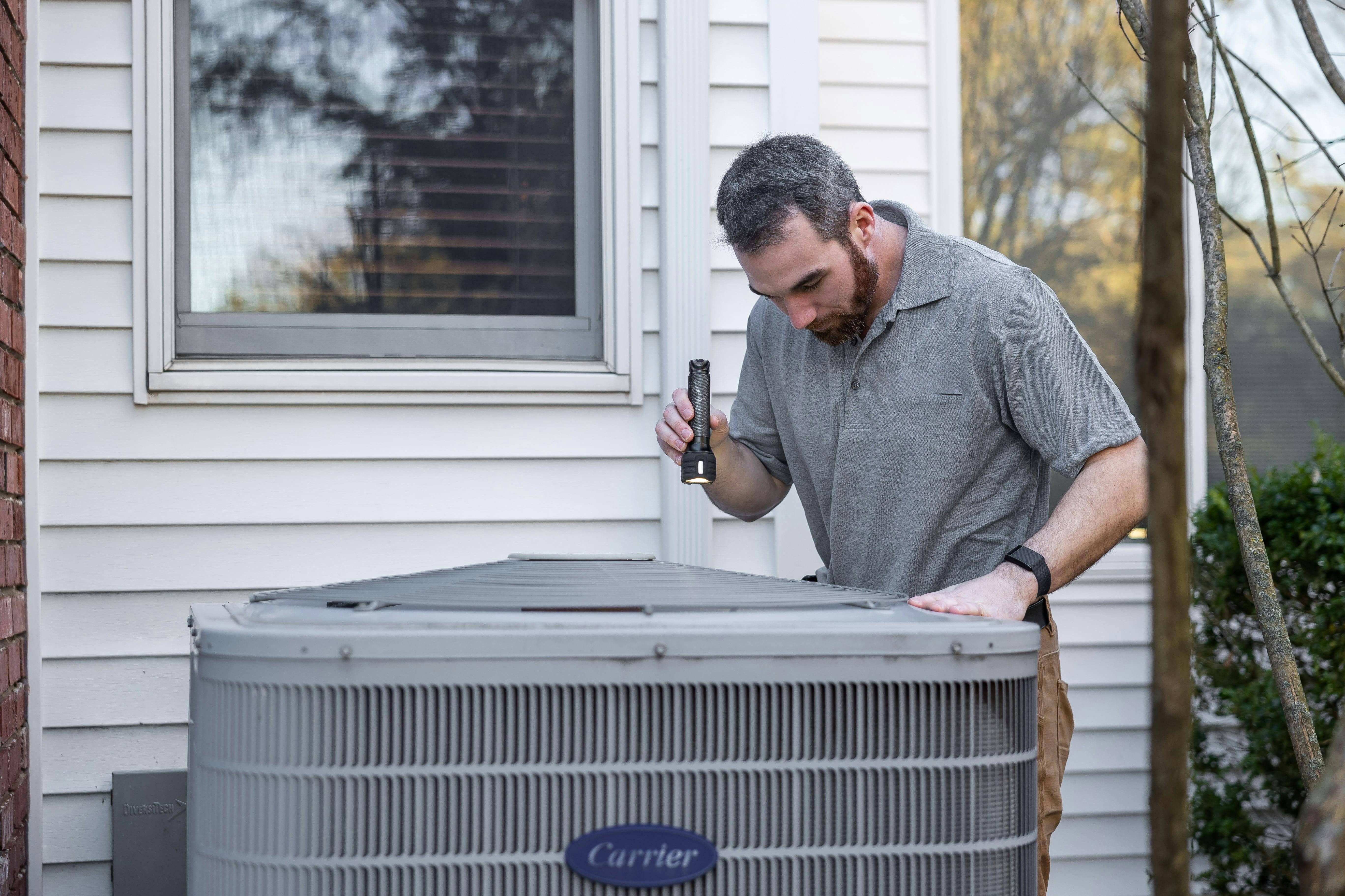 HVAC technician inspecting air conditioning unit